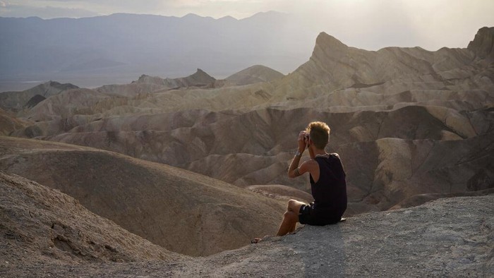 A person looks from a viewpoint, Sunday, July 11, 2021, in Death Valley National Park, Calif. Death Valley in southeastern Californias Mojave Desert reached 128 degrees Fahrenheit (53 Celsius) on Saturday, according to the National Weather Services reading at Furnace Creek. The shockingly high temperature was actually lower than the previous day, when the location reached 130 F (54 C). (AP Photo/John Locher)