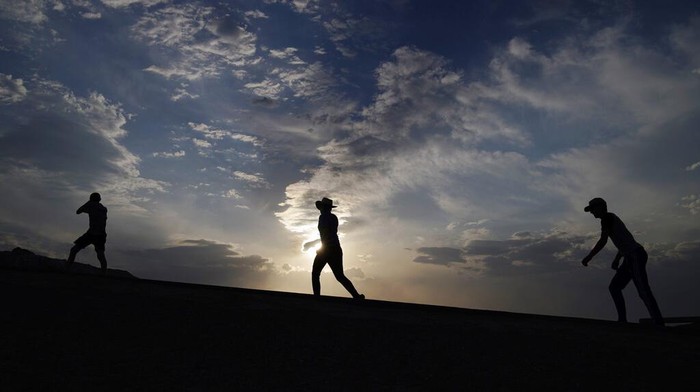 A person walks along a trail, Sunday, July 11, 2021, in Death Valley National Park, Calif. Death Valley in southeastern Californias Mojave Desert reached 128 degrees Fahrenheit (53 Celsius) on Saturday, according to the National Weather Services reading at Furnace Creek. The shockingly high temperature was actually lower than the previous day, when the location reached 130 F (54 C). (AP Photo/John Locher)