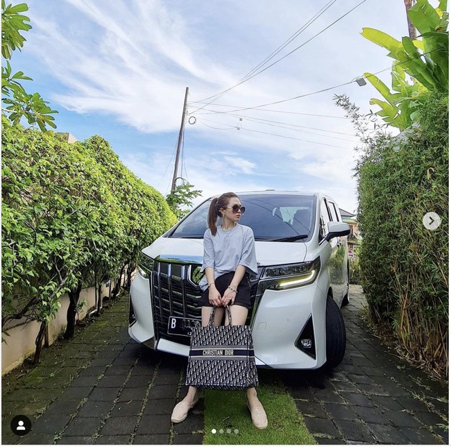 Kali ini Jessica Forrester menenteng tas Christian Dior sambil bergaya di depan mobil Alphard. Foto: Dok. Instagram @jessicaforresterr