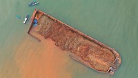 Sebuah kapal tongkang berisi nikel dalam kondisi nyaris terbalik di bibir Pantai Batu Gong, Konawe, Sulawesi Tenggara, Selasa (13/7/2021).  