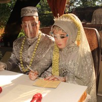 Angga menyatakan selama acara pernikahan, mereka tetap menerapkan protokol kesehatan. Bus yang semula berkapasitas 50, didekorasi untuk nikahan sehingga tinggal berkapasitas 35. “Tetapi kemarin yang ikut di (prosesi nikahan) dalam bus cuma 12 orang. Karena kita mentaati peraturan pemerintah, harus Prokes, jaga jarak. Kalau di jalan ada pemeriksaan, kita aman, kita mentaati protokol kesehatan,” tandasnya. Foto: Dok. Pribadi Titin Rachmatul Ummah dan Angga Hayu Joko Siswoyo