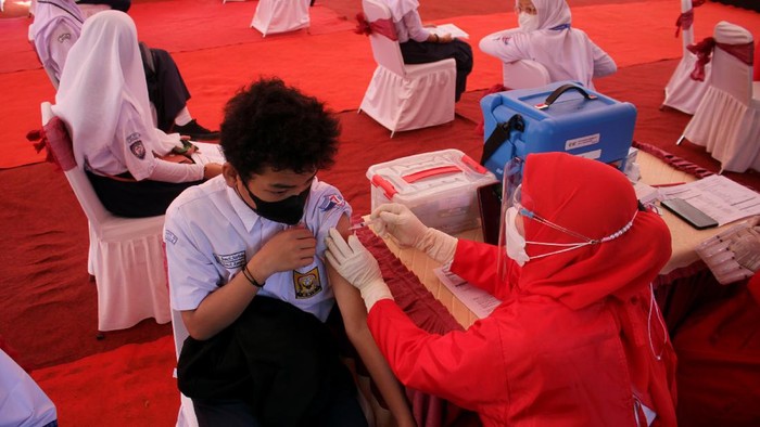 Siswa Sekolah Menengah Pertama (SMP) menerima suntikan vaksin saat vaksinasi COVID-19 secara massal di Makassar, Sulawesi Selatan, Rabu (14/7/2021). Vaksinasi pelajar secara massal yang digelar oleh Badan Inteligen Negara (BIN) tersebut menargetkan sebanyak 2.500 siswa SMP dan SMA di Sulawesi Selatan atau 8,33 persen dari target secara nasional sebanyak 30 ribu siswa. ANTARA FOTO/Arnas Padda/yu/foc.