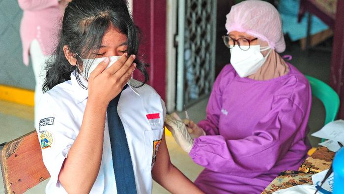 Pelajar di Berbagai Daerah Jalani Vaksinasi Massal Pelajar SMPN 1 Kota Jambi menerima suntikan vaksin COVID-19 dosis pertama dari tenaga kesehatan di Jambi, Senin (12/7/2021). Pemerintah Kota Jambi mulai melaksanakan vaksinasi massal untuk pelajar atau anak usia 12-17 tahun yang diawali di SMPN 1 kota itu guna mendukung optimalisasi perpanjangan PPKM Mikro yang telah dimulai sejak 6-20 Juli 2021. ANTARA FOTO/Wahdi Septiawan/aww.