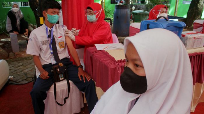 Siswa Sekolah Menengah Pertama (SMP) menerima suntikan vaksin saat vaksinasi COVID-19 secara massal di Makassar, Sulawesi Selatan, Rabu (14/7/2021). Vaksinasi pelajar secara massal yang digelar oleh Badan Inteligen Negara (BIN) tersebut menargetkan sebanyak 2.500 siswa SMP dan SMA di Sulawesi Selatan atau 8,33 persen dari target secara nasional sebanyak 30 ribu siswa. ANTARA FOTO/Arnas Padda/yu/foc.