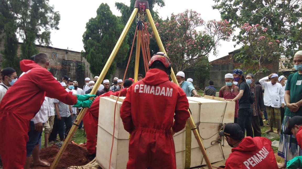 Petugas Damkar Jaktim membantu proses pemakaman jenazah seberat 300 kg di Duren Sawit, Jakarta Timur.
