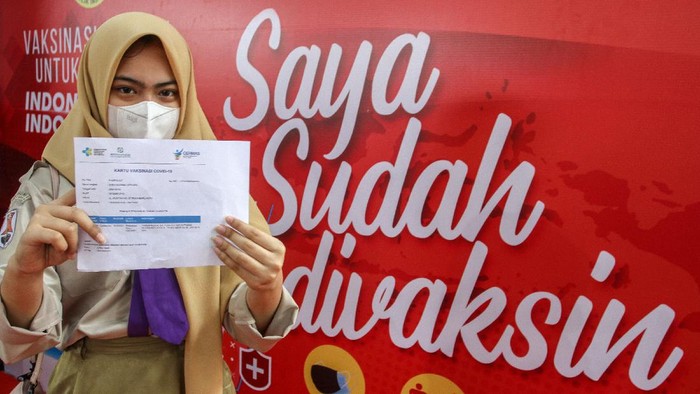 Seorang pelajar memperlihatkan kartu vaksinasi usai mendapatkan suntikkan vaksin COVID-19 di SMAN 1 Kota Pekanbaru, Riau, Rabu (14/7/2021). Pemerintah Provinsi Riau bersama Badan Intelijen Negara (BIN) menggelar vaksinasi massal untuk pelajar untuk mendukung serta mempercepat program vaksinasi nasional. ANTARA FOTO/Rony Muharrman/foc.