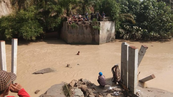 Jembatan penghubung Desa Sei Nadoras–Sei Kopas, Kecamatan Bandar Pasir Mandoge, Kabupaten Asahan, Sumut putus dihantam air sungai, Kamis (15/7/2021).