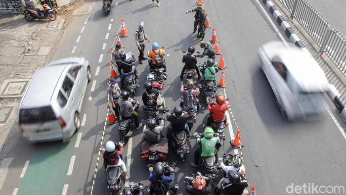 Sejumlah petugas gabungan melakukan pemeriksaan dokumen di kawasan Mampang, Jakarta Selatan, Kamis (15/7/2021). Polda Metro Jaya menyekat 100 titik yang ada di Jakarta dan sekitarnya selama penerapan Pemberlakuan Pembatasan Kegiatan Masyarakat (PPKM) darurat.