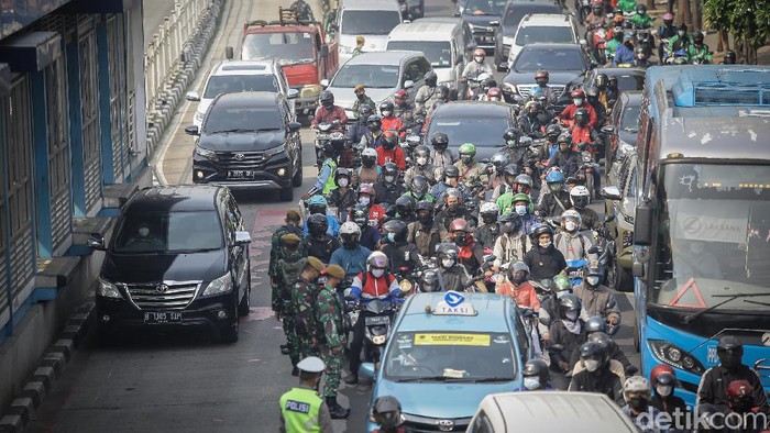 Sejumlah petugas gabungan melakukan pemeriksaan dokumen di kawasan Mampang, Jakarta Selatan, Kamis (15/7/2021). Polda Metro Jaya menyekat 100 titik yang ada di Jakarta dan sekitarnya selama penerapan Pemberlakuan Pembatasan Kegiatan Masyarakat (PPKM) darurat.