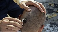 Jamaah haji mencukur rambut di kepalanya sebagai bagian Tahallul yang merupakan rangkaian terakhir dari pelaksanaan haji di lembah Mina, timur kota suci Mekah, Arab Saudi. 