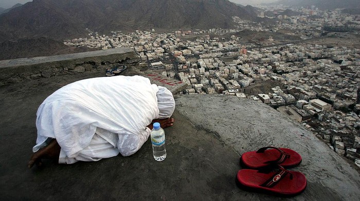 Musim Haji JEBEL AL-NOOR, SAUDI ARABIA - JANUARY 16: A Muslim Pilgrim girl prays on Jebel al-Noor, or Mount of Light, 6 kms from Mecca where they will visit Ghar Heera, or Heera cave January 16, 2005 as part of annual Hajj in Jebel al-Noor, Saudi Arabia. Around two million Muslim pilgrims from around the world are expected to converge on the city of Mecca for the holy Muslim day of Al-Hajj or Bilgirame Day. (Photo by Abid Katib/Getty Images)