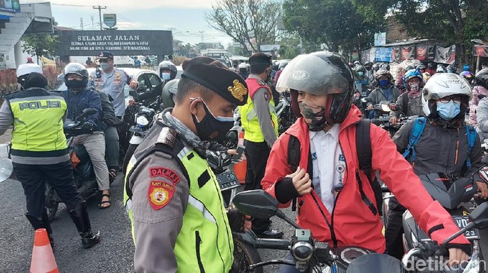 Petugas melakukan pemeriksaan terhadap pengendara yang akan masuk ke Kota Bandung.