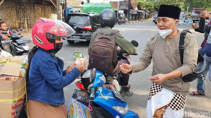 YouTuber Ustaz Ujang Busthomi bagikan uang ke pengendara motor.