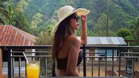 Berpose candid menikmati pemandangan bukit, Alyssa Spischak ditemani dengan segelas minuman segar. Orange juice yang tampak masih penuh di atas meja. Foto: Instagram @alyssaspischak
