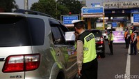 Tampak petugas memeriksa surat jalan seorang pengendara.