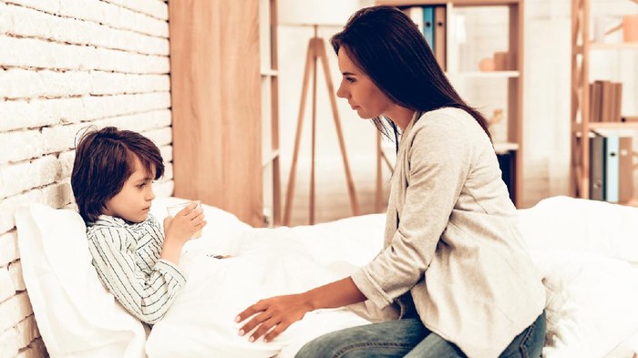 Ilustrasi anak sakit atau batuk Mother Giving Medicine to Sick Son Lying Bed. Caring Mom Giving Sick Boy Pills. Worried Mother Giving Glass of Water to Ill Kid. Hospital Concept. Healthy Concept. Parent Concept.