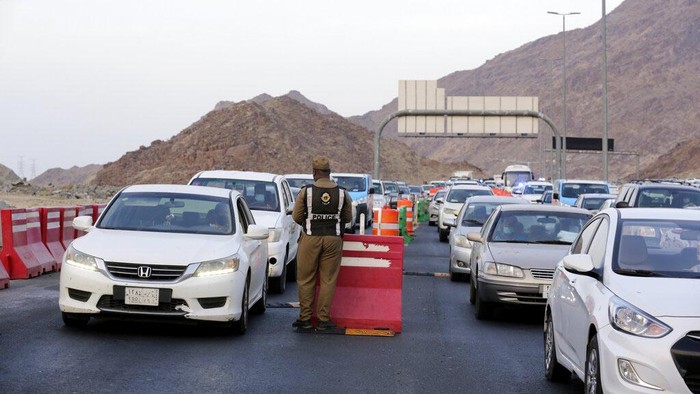 A Saudi policeman checks vehicles at a check point at the Muslim holy city of Mecca, ahead of the upcoming annual hajj pilgrimage, Thursday, July 15, 2021. The pilgrimage to Mecca required once in a lifetime of every Muslim who can afford it and is physically able to make it, used to draw more than 2 million people. But for a second straight year it has been curtailed due to the coronavirus with only vaccinated people in Saudi Arabia able to participate. (AP Photo/Amr Nabil)