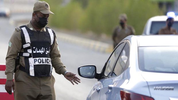 A Saudi policeman checks vehicles at a check point at the Muslim holy city of Mecca, ahead of the upcoming annual hajj pilgrimage, Thursday, July 15, 2021. The pilgrimage to Mecca required once in a lifetime of every Muslim who can afford it and is physically able to make it, used to draw more than 2 million people. But for a second straight year it has been curtailed due to the coronavirus with only vaccinated people in Saudi Arabia able to participate. (AP Photo/Amr Nabil)