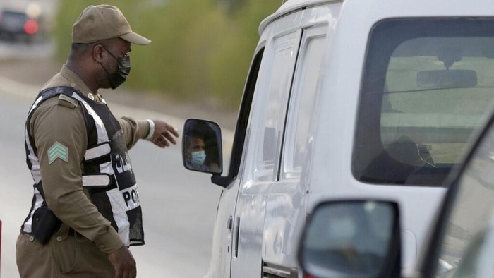 A Saudi policeman checks vehicles at a check point at the Muslim holy city of Mecca, ahead of the upcoming annual hajj pilgrimage, Thursday, July 15, 2021. The pilgrimage to Mecca required once in a lifetime of every Muslim who can afford it and is physically able to make it, used to draw more than 2 million people. But for a second straight year it has been curtailed due to the coronavirus with only vaccinated people in Saudi Arabia able to participate. (AP Photo/Amr Nabil)