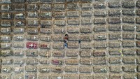 Foto udara warga berziarah di dekat pusara keluarganya di area pemakaman khusus COVID-19 di TPU Rorotan, Cilincing, Jakarta Utara, Kamis (15/7/2021).  