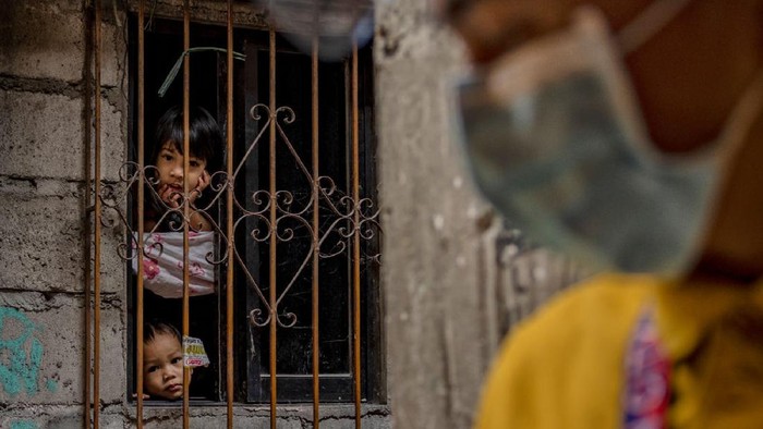 MANILA, PHILIPPINES - APRIL 21: A cemetery worker partially wearing protective clothing tells children loitering to head home, outside a public crematorium on April 21, 2021 in Pasay, Metro Manila, Philippines. Public crematoriums are struggling in the Philippines as the countrys Covid-19 death toll mounts amid the worst surge in cases since the pandemic began. The country is currently suffering the worst Covid-19 outbreak in Southeast Asia with more than 962,000 confirmed cases, more than 19,000 deaths, and with the most number of active cases in the region.