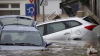Mobil-mobil terendam saat jalan di Pepinster, Belgia, berubah seperti sungai akibat banjir. 