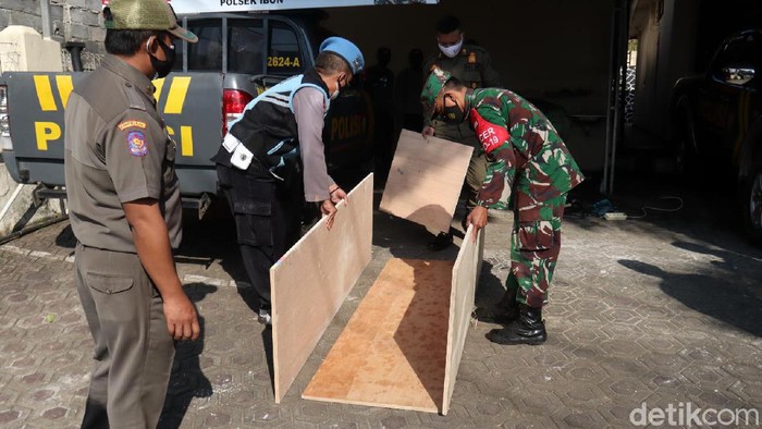 Halaman parkir Mapolsek Ibun, Polresta Bandung disulap menjadi bengkel untuk membuat peti jenazah. Peti ini diberikangratis kepada korban COVID-19.