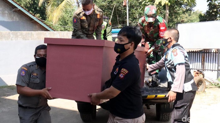Halaman parkir Mapolsek Ibun, Polresta Bandung disulap menjadi bengkel untuk membuat peti jenazah. Peti ini diberikangratis kepada korban COVID-19.