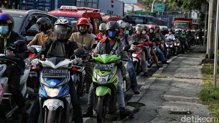 Petugas gabungan memeriksa dokumen pegendara motor dan mobil arah ke Jakarta di Pos Pegendalian Mobilitas  PPKM Darurat di kawasan Jalan Medan Satria, Bekasi, Jawa Barat, Jumat (16/7/2021).
