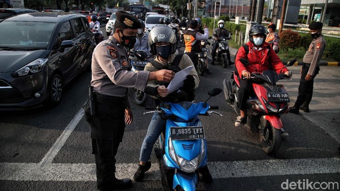 Petugas gabungan memeriksa dokumen pegendara motor dan mobil arah ke Jakarta di Pos Pegendalian Mobilitas  PPKM Darurat di kawasan Jalan Medan Satria, Bekasi, Jawa Barat, Jumat (16/7/2021).