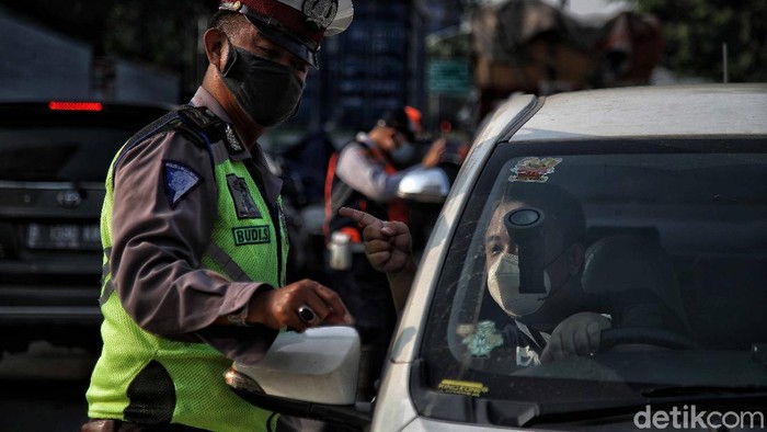 Petugas gabungan memeriksa dokumen pegendara motor dan mobil arah ke Jakarta di Pos Pegendalian Mobilitas  PPKM Darurat di kawasan Jalan Medan Satria, Bekasi, Jawa Barat, Jumat (16/7).