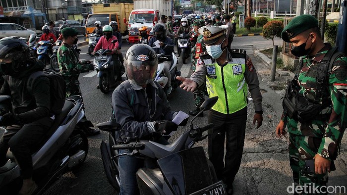 Ramainya kendaraan di Penyekatan Kawasan Bekasi Petugas gabungan memeriksa dokumen pegendara motor dan mobil arah ke Jakarta di Pos Pegendalian Mobilitas PPKM Darurat di kawasan Jalan Medan Satria, Bekasi, Jawa Barat, Jumat (16/7/2021).