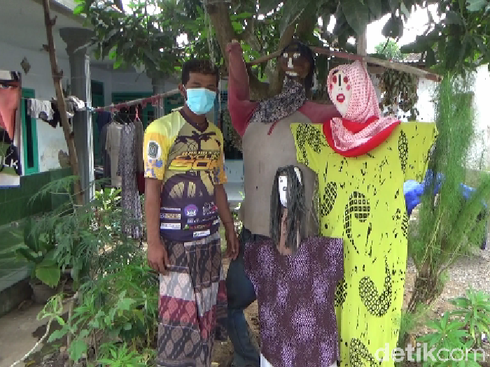 Ada pemandangan tidak biasa di Desa Kutorenon, Kecamatan Sukodono, Lumajang. Warga memasang orang-orangan di depan rumah.