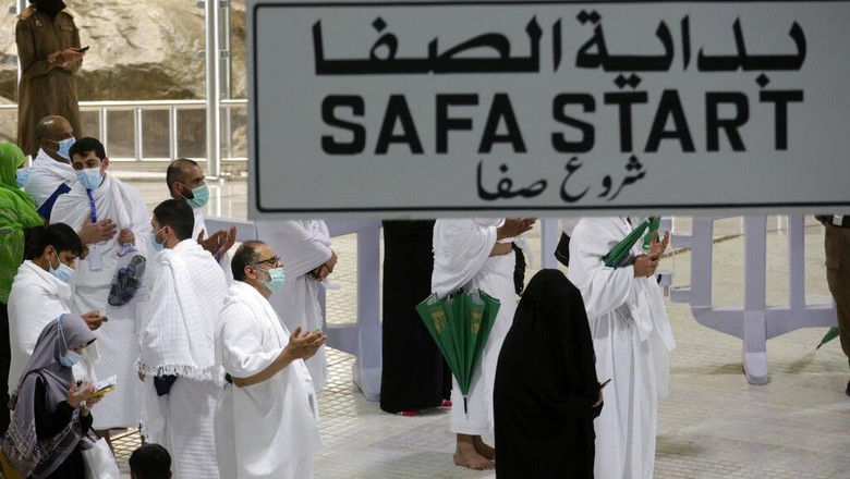 Jemaah Tiba di Mekkah, Siap Mulai Rangkaian Haji A Saudi police woman, left, who is recently deployed to the service, at top left, stands alert in front of the Al-Safa mountain, as pilgrims pray at the Grand Mosque, at the Grand Mosque, a day before the annual hajj pilgrimage, Saturday, July 17, 2021. The pilgrimage to Mecca required once in a lifetime of every Muslim who can afford it and is physically able to make it, used to draw more than 2 million people. But for a second straight year it has been curtailed due to the coronavirus with only vaccinated people in Saudi Arabia able to participate. (AP Photo/Amr Nabil)