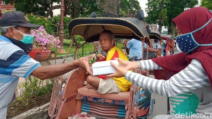 Keluarga di Klaten berbagi nasi untuk penarik becak, melanjutkan hobi almarhumah ibu, Jumat (16/7/2021).