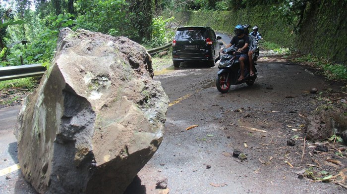 LONGSOR BATU BESAR TERNATE Sejumlah pengendara menghindari batu besar yang longsor dan menutup sebagian jalan lingkar di Pulau Ternate, Kota Ternate, Provinsi Maluku Utara, Sabtu (17/7/2021). Longsor batu besar dari gunung tersebut mengganggu arus lalu lintas, dan insiden terjadi akibat curah hujan yang tinggi melanda Kota Ternate sejak Jumat (16/7) . ANTARA FOTO/Harmoko Minggu/FBA/nz.