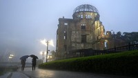 Orang-orang berjalan di dekat Monumen Perdamaian Hiroshima di Hiroshima, Jepang barat. 