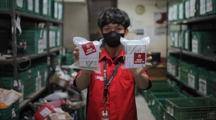 PENDISTRIBUSIAN OBAT COVID-19 GRATIS Pekerja menunjukkan paket obat COVID-19 di salah satu gerai ekspedisi SiCepat pengiriman barang gerai di Jalan K.S Tubun, Petamburan, Jakarta, Sabtu (17/7/2021). Pemerintah pusat resmi membagikan sebanyak 300.000 paket obat gratis berupa multivitamin, Azithtromycin, dan Oseltamivir bagi pasien COVID-19 yang menjalani isolasi mandiri di Pulau Jawa dan Bali. ANTARA FOTO/ Reno Esnir/aww. *** Local Caption ***