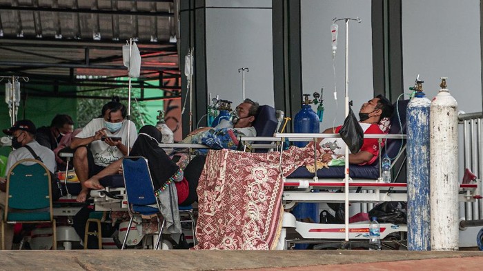 Sejumlah pasien berada di teras gedung Instalasi Gawat Darurat (IGD) Rumah Sakit Umum Daerah (RSUD) Jayapura, Papua, Jumat (16/7/2021). Wakil Direktur Umum dan Keuangan RSUD Jayapura dr Silwanus Sumule mengaku kapasitas ruangan di rumah sakit sudah terisi penuh, hasil antigen pasien yang reaktif diberikan tempat diluar gedung. ANTARA FOTO/Indrayadi TH/hp.