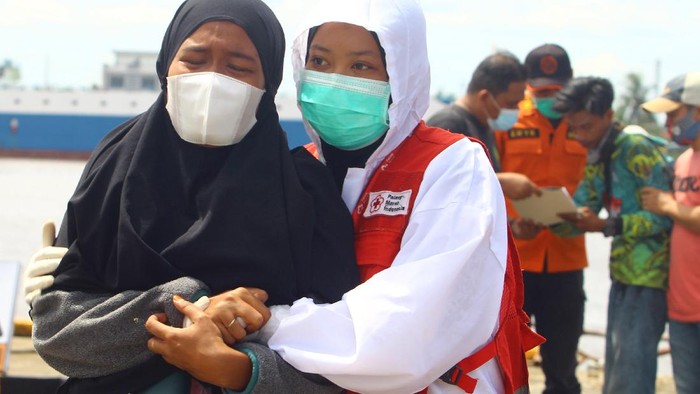 Dua petugas medis menuntun Purwanto (tengah), awak Kapal Motor Usaha Abadi yang selamat dari kecelakaan kapal tenggelam saat tiba di dermaga Pelabuhan Kantor Kesyahbandaran dan Otoritas Pelabuhan Pontianak, Kalimantan Barat, Jumat (16/7/2021). Hingga saat ini Basarnas masih melakukan pencarian terhadap 44 awak dari 16 kapal motor yang tenggelam di Perairan Kalbar akibat cuaca buruk pada Selasa (13/7/2021) malam dan Rabu pagi (14/7/2021). ANTARA FOTO/Jessica Helena Wuysang/hp.