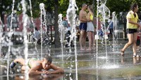 Salah satunya dengan bermain air di air mancur taman. AP Photo/Pavel Golovkin  
