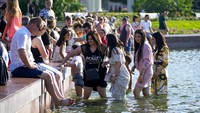 Mulai dari anak-anak hingga orang dewasa ramai mengunjungi air mancur yang ada di taman pusat kota. AP Photo/Alexander Zemlianichenko  