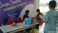 Seorang karyawan TMMIN tengah mendampingi salah satu warga yang melakukan vaksinasi gratis tersebut.