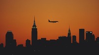 Pemandangan bangunan Empire State Building di Kota New York, Amerika Serikat, dengan latar matahari terbenam kian memesona karena dipotret tepat saat sebuah pesawat tengah mengudara. Jamie Squire/Getty Images.