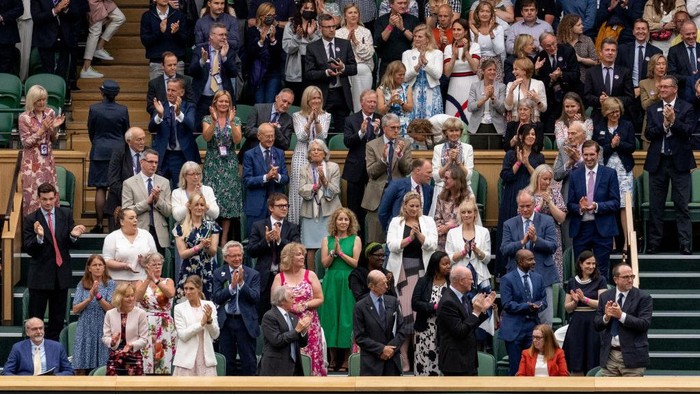 LONDON, ENGLAND - JUNE 28: The Royal Box stands and applauds University of Oxford Professor Sarah Gilbert (seated in red, bottom right) one of the people behind the Astra Zeneca COVID-19 vaccine ahead of the opening match on Centre Court during Day One of The Championships - Wimbledon 2021 at All England Lawn Tennis and Croquet Club on June 28, 2021 in London, England. (Photo by AELTC/Joe Toth-Pool/Getty Images)