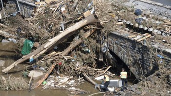 Polisi mengamati puing-puing di jembatan Ahr River di Altenahr, Jerman, untuk mencari kemungkinan korban. Banyak rumah di sekitarnya mengalami kerusakan. Sebagian wilayah Eropa dilanda banjir bandang yang parah, paling hebat menimpa Jerman. Foto: AP/Peter Kneffel