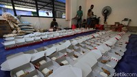 Para relawan menyiapkan menu makanan yang akan dibagikan kepada warga yang terpapar COVID-19, tenaga kesehatan, dan personel yang berjaga di rumah sakit.