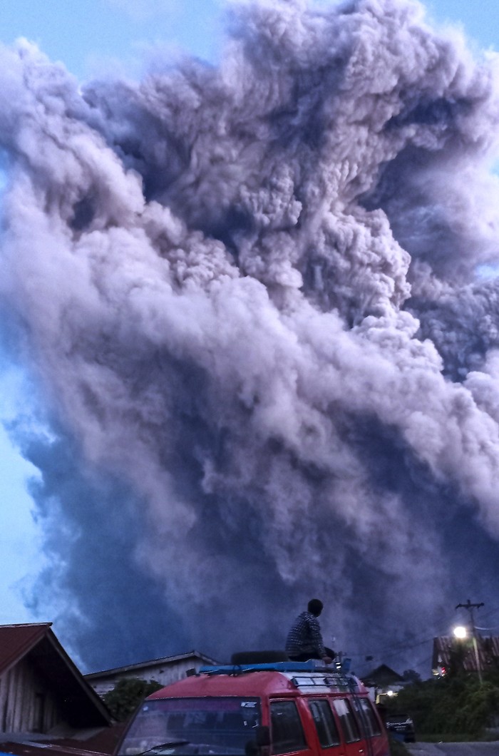 ERUPSI GUNUNG SINABUNG Warga mengamati Gunung Sinabung yang menyemburkan material vulkanik di Desa Kutarayat, Naman Teran, Karo, Sumatera Utara, Senin (19/7/2021). Gunung Sinabung erupsi dengan tinggi kolom 5.000 meter di atas puncak atau 3.460 m di atas permukaan laut. ANTARA FOTO/Sastrwawan Ginting/Lmo/aww.