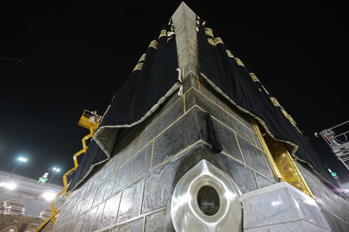 This picture taken on July 19, 2021 on the night before the start of the annual hajj pilgrimage, shows a view of the Hajar al-Aswad or the Black Stone, a rock set to the eastern corner of the Kaaba believed by Islamic tradition to date to the time of Adam and Eve, as labourers put on the new Kiswa, the protective cover that engulfs the shrine, made from black silk and gold thread and embroidered with Koran verses, in Saudi Arabias holy city of Mecca. - The drape which engulfs the Kaaba is formally called Kiswa and is changed every year at the culmination of the annual hajj, or pilgrimage, when the pilgrims have left Mecca to go to Arafat, the starting point of their hajj journey. (Photo by - / AFP)