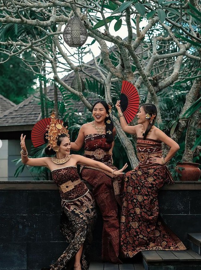 Dia tidak berpose sendiri, namun bersama dua teman lainnya. Inilah potret ketiganya yang tampil mempesona dengan kain tenun Bali. Foto: dok. Instagram/@lunamaya